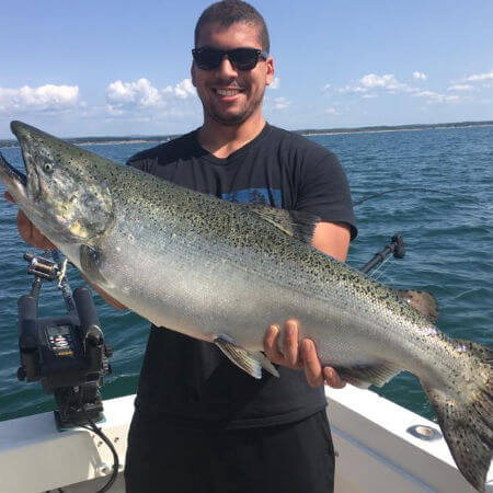man from Sandy Pond NY holds up impressive king salmon