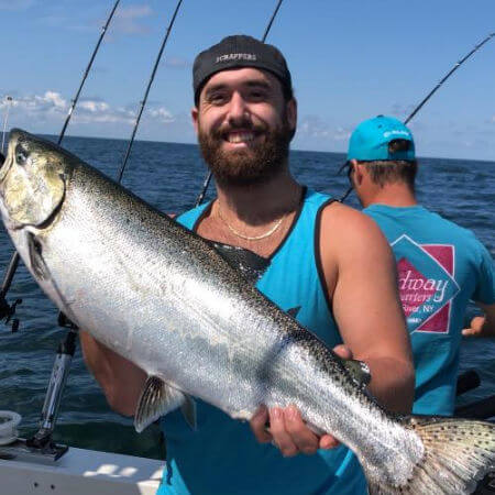 man from Sodus Point NY holding a heavy king salmon on an afternoon charter trip