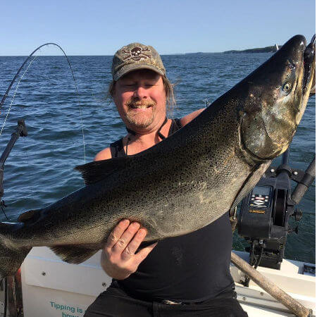 angler holds out a huge Lake Ontario king salmon