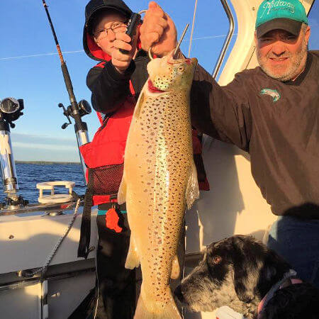 young angler needs help holding up his brown trout on a Pulaski NY charter